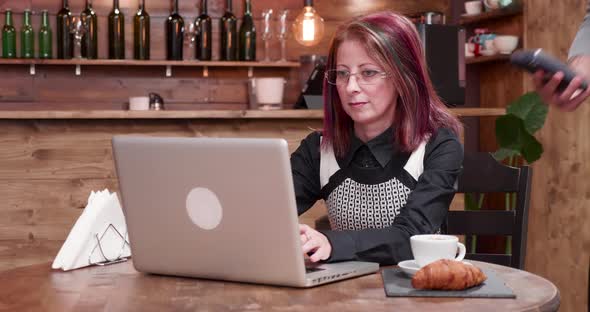 Adult Woman Pays with NFC Payments in a Vintage Coffee Shop