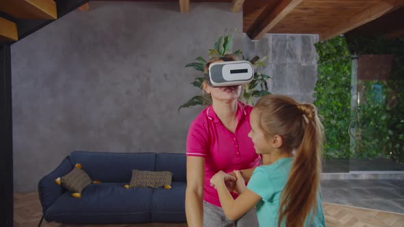 Excited Mom in Vr Headset Playing Game with Daughter