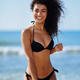 Young Arabic Woman with Beautiful Body in Swimwear Smiling on a