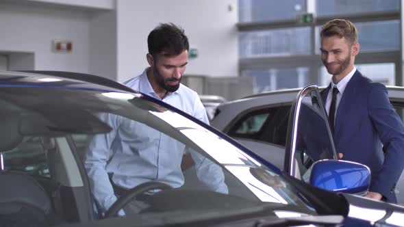 Man Buyer Testing Car Inside in Auto Dealership