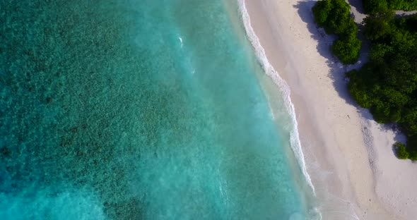 Beautiful flying copy space shot of a white sand paradise beach and aqua blue ocean background in be