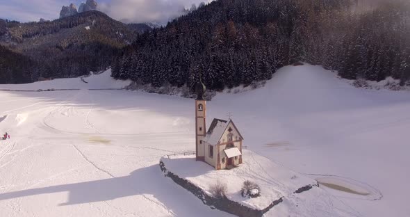 AERIAL: Church with snow in Dolomites in Italy