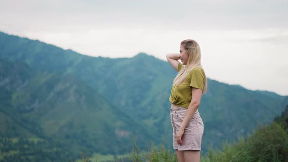 Smiling Blonde Woman Amazed of Picturesque Mountains View