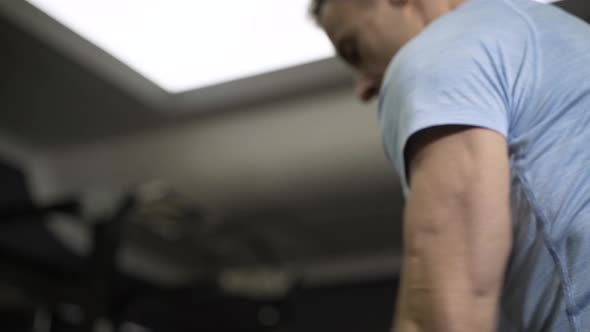 Man doing side-to-side chops exercise with elastic band at the gym.