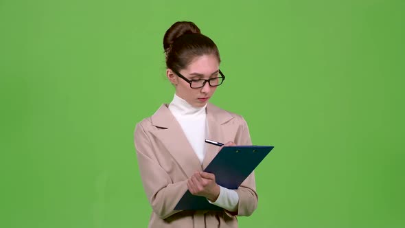 Manager Fills the Questionnaire with a Pen on a Paper Tablet. Green Screen. Slow Motion