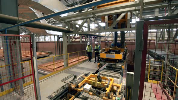 Brickproducing Plant with Two Employees Walking and Observing It