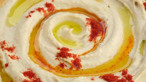 Hummus with smoked paprika and olive oil close up, rotation