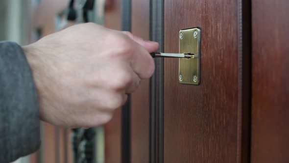 Man closes the door with a key, close-up of a hand
