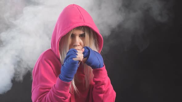 Female Boxer Prepares to Punch at a Boxing Studio. Woman Boxer in Motion