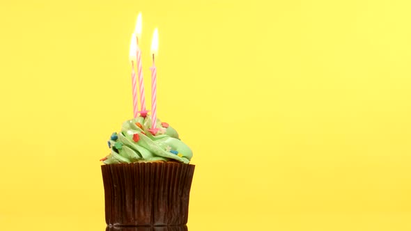 Tasty Birthday Cupcake with Three Candle, on Yellow Background