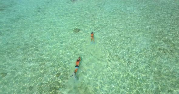 Aerial drone view of a man and woman couple snorkeling with seascooters