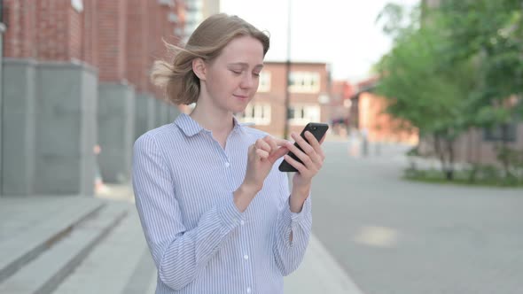 Woman Using Smartphone While Standing in Street
