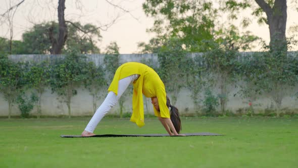 Advance Yoga pose is being done by an Indian woman in a park