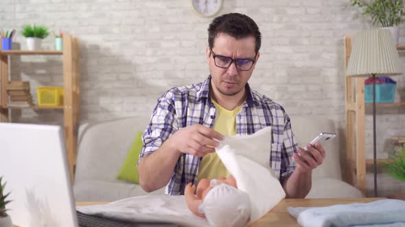 Young Fathertobe Has Problems with Learning Swaddling a Baby Doll and Looking at the Camera