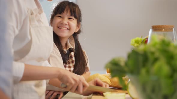 Asian happy family making food preparation with young kid daughter together in kitchen room at house