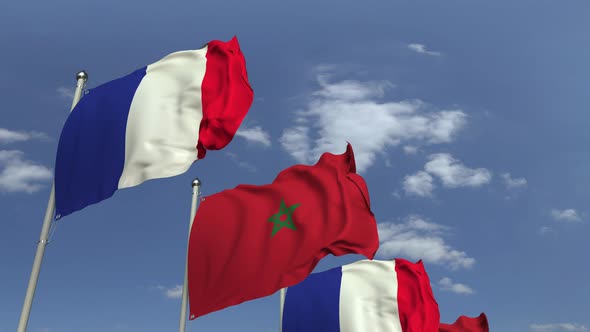 Waving Flags of Morocco and France on Sky Background