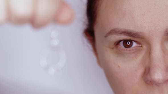 Woman Looks at Precious Expensive Gold Diamond Ring on Chain