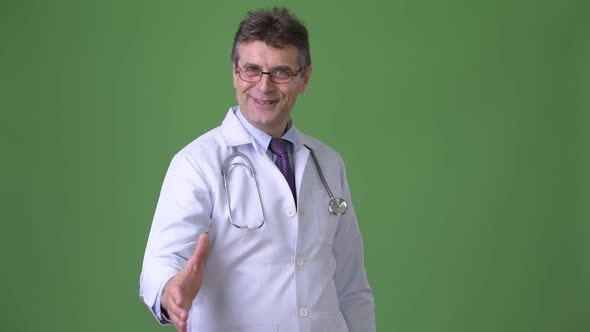 Mature Handsome Man Doctor Against Green Background