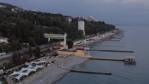 Long Train Drives Along Railroad on Calm Sea Coastline