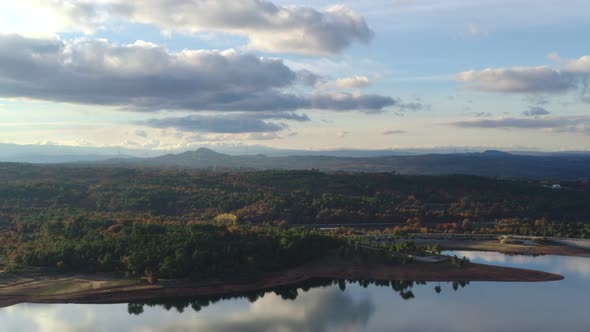 Drone aerial view of a lake reservoir of a dam with perfect reflection on the water of the sunset in