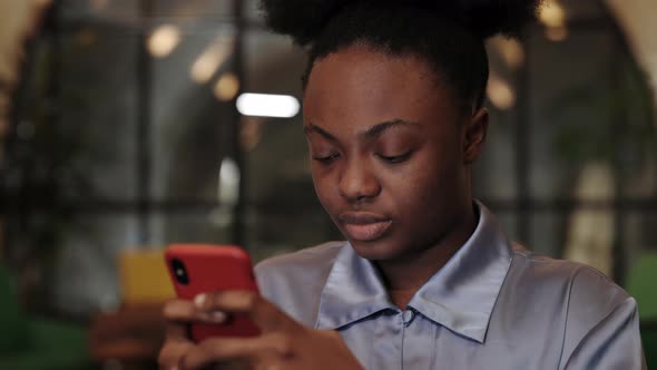 Crop View of Afro American Woman in Blouse Using Smartphone While Sitting in Chair