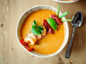 ps on wooden table. Popular spicy Thai dish Tom Yam top view. Thailand food and Thai cuisine. Natural day light