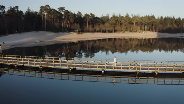 Arial view of a woman on the bridge at Henschotermeer lake.