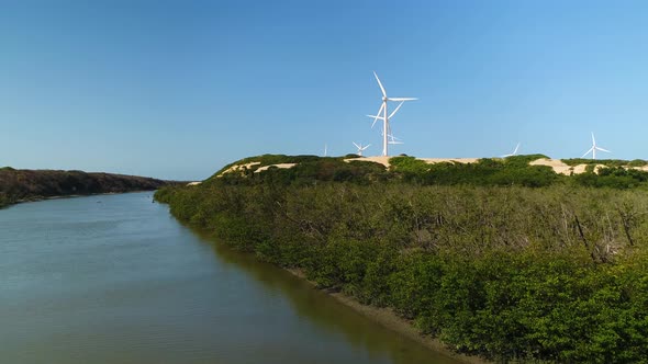 Aerial view of wind turbines on the top of dunes near a river, Brazil.