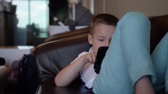 Kid with Digital Tablet Relaxing in Airport Lounge