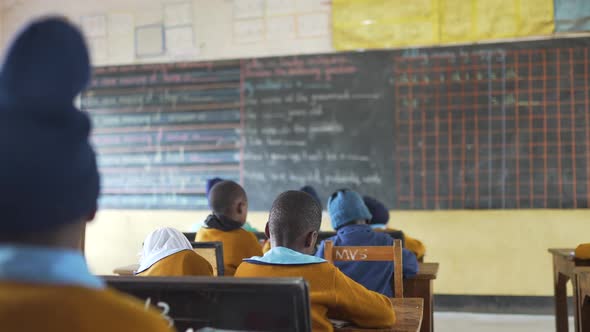 African school with children doing class looking the blackboard. Tanzania, Africa 4K.