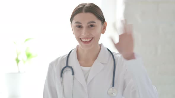 Portrait of Female Doctor Waving Towards the Camera