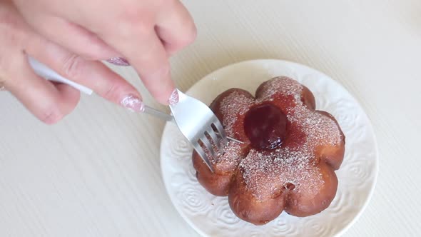 A Woman Cuts A Donut With Jam In Powdered Sugar. Donuts In The Form Of A Flower. Close Up.