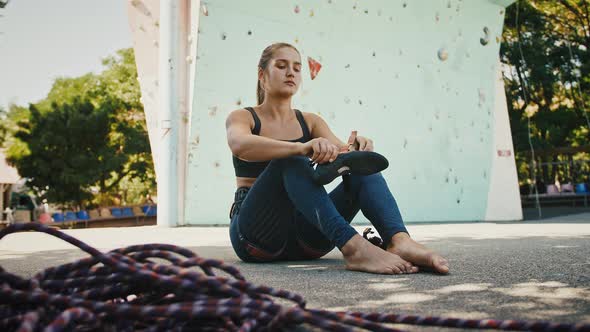 Fit Woman Putting on Her Rock Climbing Shoes Preparing to Rock Climb Outdoors
