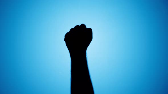 Man Showing Fist Protest Gesture with Fingers Isolated on Blue Neon Background