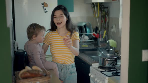 Cinematic Authentic Shot of Happy Mother and Her Little Toddler Baby Boy Son are Having Fun to Make