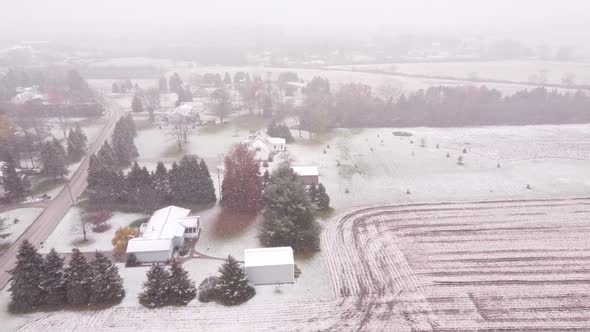 Slow motion backward shot of the place Snowy Countryside, Southeast Michigan of frozen trees and bui