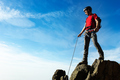 A climber helps his partner to reach the summit of a mountain pe - PhotoDune Item for Sale