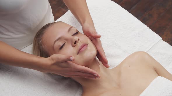 Young, healthy and beautiful woman gets massage therapy in the spa salon.