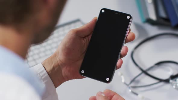 Caucasian male doctor having video call consultation using smartphone