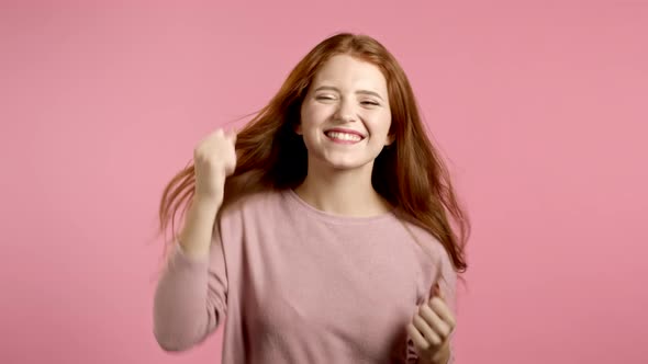 Beautiful Woman Dancing Energetically and Actively on Pink Studio Background. Cute Girl. Party