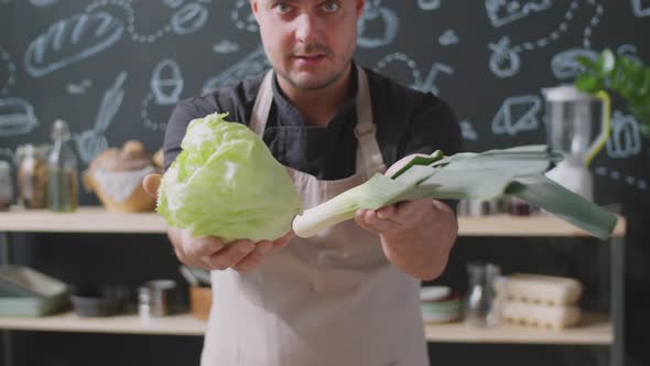 Male Chef Showing Vegetables at Camera