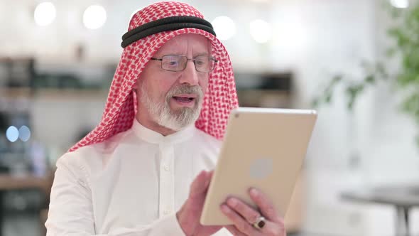 Senior Old Arab Businessman Celebrating Success on Tablet