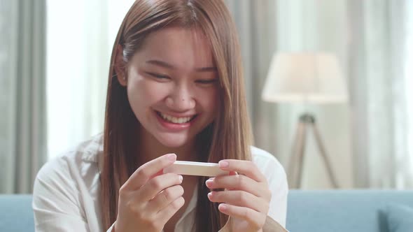 Close Up Happy Young Asian Woman Looking At Pregnancy Test