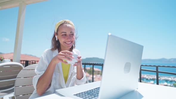 Pleased Woman Enjoying Morning Coffee While Sitting on Terrace with Sea View on Turkish Resort Using