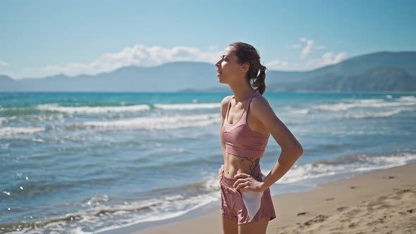 Young Active Sporty Athlete Smiling Woman is Taking a Break After Making Running and Jogging Workout