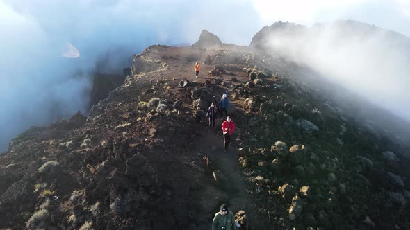 Drone footage of people walking on the summit of the Piton des Neiges at the Reunion island.