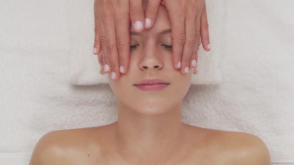 Young, healthy and beautiful woman gets massage therapy in the spa salon.