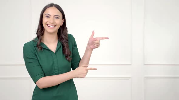 Indian woman pointing right at Copy space