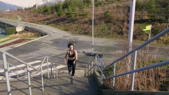 Fit young woman running up steps exercising Slow motion