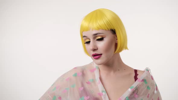Closeup portrait of woman with colourful makeup in futuristic style wearing at yellow wig